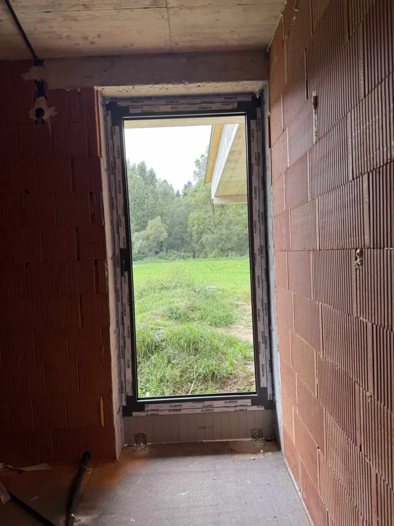 Hliníkové dvere 26 Hliníkový otvor s výhľadom do záhrady na stavbe